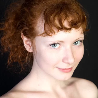 Обаятельная рыжая девица Rochelle на темном фоне